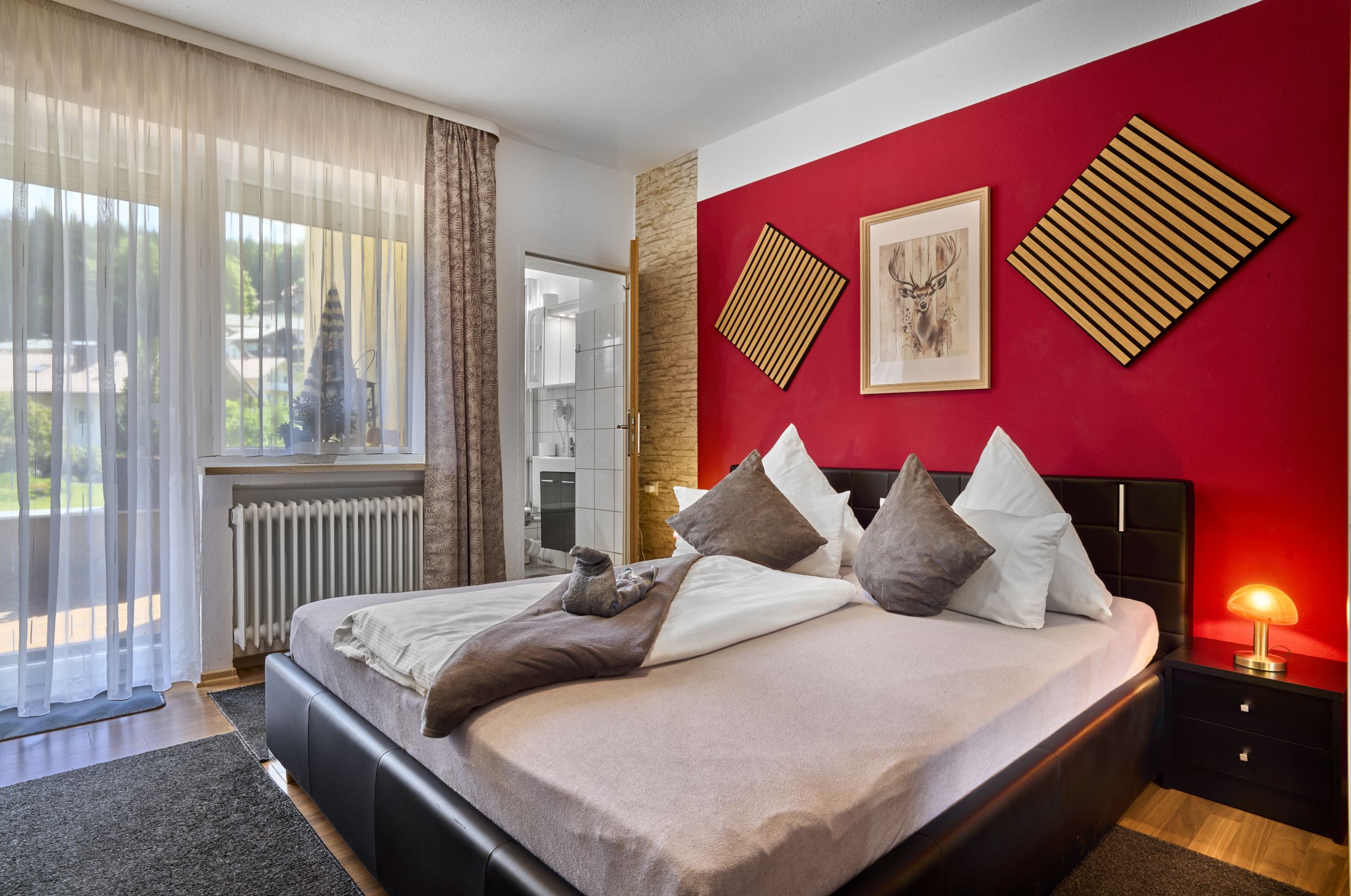Doppelzimmer mit roter Wand und großem Bett