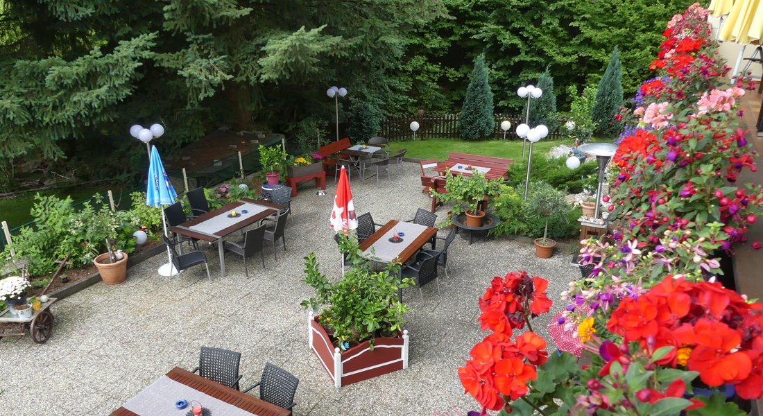 Terrasse mit Blumen und Sitzplätzen im Sommer