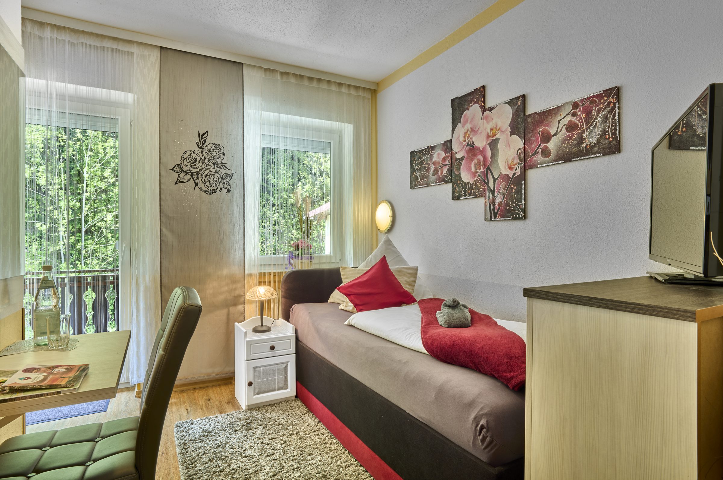 Einzelzimmer mit Bett, Schreibtisch und Fenster